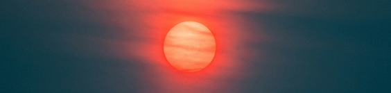 Glowing orange sun in a dark sky